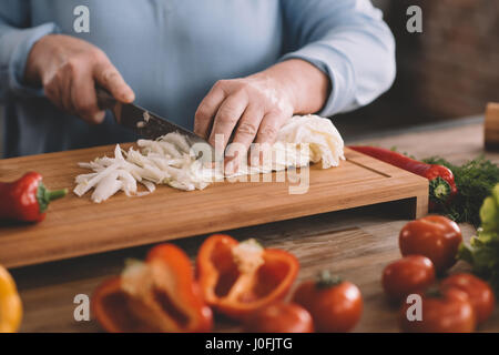 Vue partielle de senior woman chopping oignon salade Banque D'Images