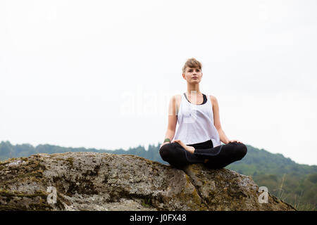 Young Beautiful woman doing yoga sur le sommet des montagnes Banque D'Images