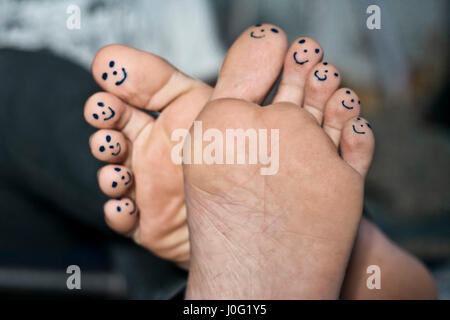 Tous les dix orteils de pieds avec smiley faces dessiné avec un stylo noir. Banque D'Images