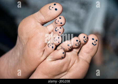 Tous les dix orteils de pieds avec smiley faces dessiné avec un stylo noir. Banque D'Images