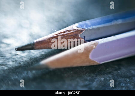 Deux crayons différents sur une surface bleutée. Banque D'Images