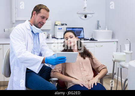 Dentiste au cours digital tablet with female patient dans une clinique dentaire Banque D'Images