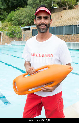 Portrait de maître-nageur avec bouée de sauvetage permanent de la piscine près de Banque D'Images