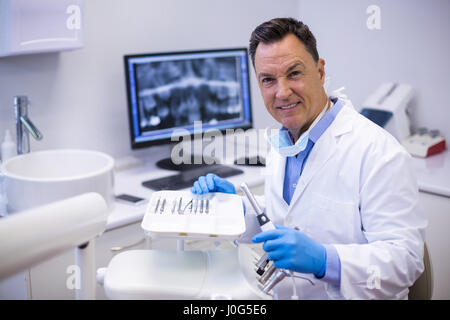 Portrait of smiling holding dentiste Clinique dentaire dans la pièce à main Banque D'Images