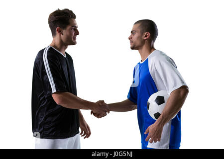 Deux joueurs de football shaking hands against white background Banque D'Images