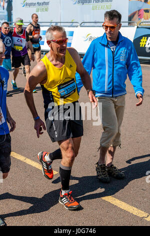 Un athlète âgés épuisés s'approche de la ligne d'arrivée au Marathon de Brighton, Brighton, Sussex, UK Banque D'Images