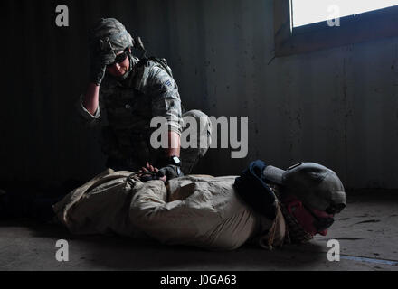 Airman Senior Austin Mills, 569e Escadron de la police des Forces américaines patrouilleur, appréhende la simulation d'une force opposée pendant les opérations urbaines partie de la 435e Escadron des Forces de sécurité au sol du Centre de préparation au combat au cours des opérations de sécurité de l'Armée américaine sur l'Allemagne, la garnison, Baumholder 4 Avril, 2017. Au cours d'une mission d'obtenir des renseignements d'une simulation d'affaires chef de village, moulins et d'autres étudiants ont été attaqués par des cadres dans le rôle des forces opposées avec tours et flash bangs vierge. Aviateurs affectés à la 86e, SFS SFS SFS 422nd, 100e, et 569e USFPS p Banque D'Images