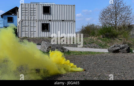 La fumée s'élève jaune hors de grenade de fumée au cours de l'exploitation urbaine partie de la 435e Escadron des Forces de sécurité au sol du Centre de préparation au combat au cours des opérations de sécurité de l'Armée américaine sur l'Allemagne, la garnison, Baumholder 4 Avril, 2017. Les étudiants avaient pour mission de parler à un chef de village et d'obtenir des renseignements de lui lorsqu'ils ont été attaqués et ont dû neutraliser la menace et le faire revenir à leur base. Aviateurs affectés à la 86e, SFS SFS SFS 422nd, 100e, et 569e Escadron de la police des forces américaines ont participé au cours. (U.S. Photo de l'Armée de l'air par la Haute Airman Tryphena Mayhugh) Banque D'Images