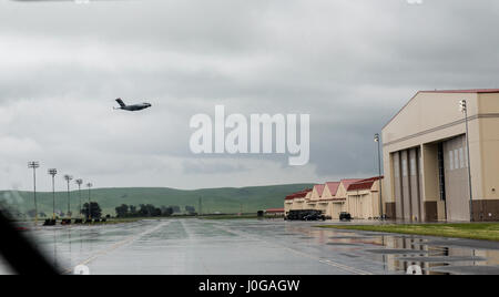 Un C-17 Globemaster vu à travers un pare-brise du bus de l'équipage quitte Travis Air Force Base sur une matinée pluvieuse, Avril 7, 2017. Le Boeing C-17 Globemaster III est un grand avion de transport militaire. Il a été développé pour l'United States Air Force (USAF) entre les années 1980 et le début des années 1990 par McDonnell Douglas. Le C-17 reprend le nom de deux précédents moteur à pistons d'avions-cargos militaires, le Douglas C-74 Globemaster et le Douglas C-124 Globemaster II. Le C-17 effectue couramment des missions de transport aérien stratégique, le transport de troupes et de fret dans le monde entier ; des rôles supplémentaires : ia tactique Banque D'Images