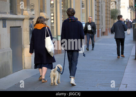 Jeune couple branché avec chien marcher dans la ville de Glasgow Banque D'Images