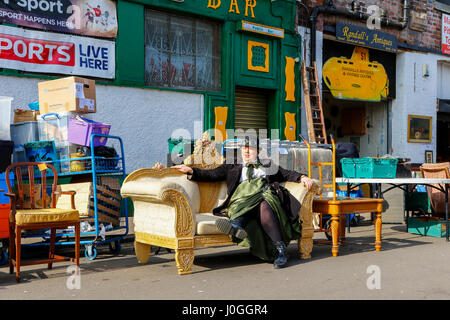 Femme assise sur une table aux Barras, célèbre marché aux puces de Glasgow, Glasgow, Écosse, Royaume-Uni Banque D'Images