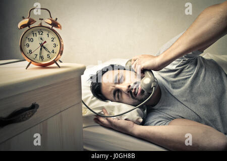 L'homme au téléphone au lit Banque D'Images