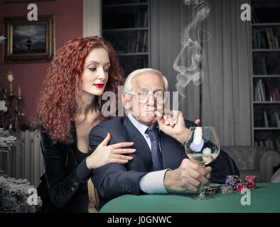 Vieil homme et jeune femme jouant au poker Banque D'Images