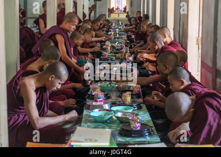 Les moines étudiant bouddhiste de manger le déjeuner dans leur restaurant de la monastère Mahagandayon Banque D'Images