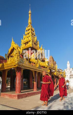 Les moines bouddhistes débutants balade autour du complexe sacré Shwezigon Paya, l'un des plus vénérés du Myanmar pagodes, dans Nyaung U, Bagan, Myanmar (Birmanie). Banque D'Images