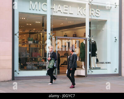 Boutiques boutique Manchester à la mode Michael Kors dans le centre-ville centre représentant la vitrine et deux femmes de race blanche au premier plan. Banque D'Images