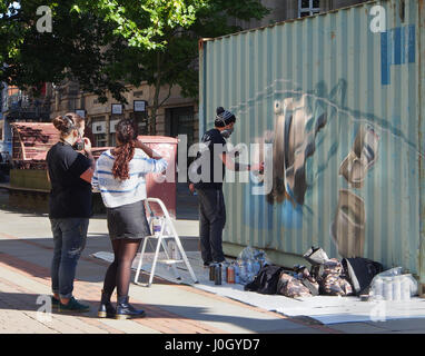 Graffitti juridique, graffiti, Graffiti, un jeune homme donne une démonstration de peinture avec la peinture en aérosol sur un récipient à St Anne's Square à Manchester, Banque D'Images