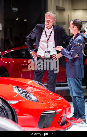 New York, NY - 12 avril 2017. Andreas Prueninger, le chef de la file de voitures GT de Porsche, ce qui donne une interview. Une nouvelle Porsche 911 GT3 est au premier plan. Banque D'Images