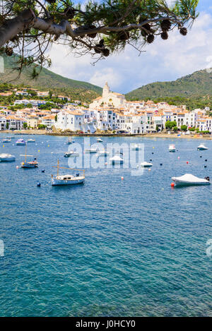 Village blanc de Cadaques surmontée de l'église de Santa Maria donnant sur des bateaux dans les eaux bleues de la baie de Cadaques, Figueres, en Catalogne, Espagne Banque D'Images