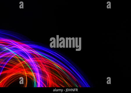 Photo de light painting fairy lights multicolores, dans un motif swirly sur fond noir. Photos à longue exposition. Multi couleur néon. Banque D'Images
