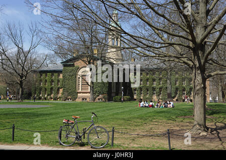 Princeton, NJ, USA - Le 11 avril 2017, Campus de l'Université de Princeton : au printemps. L'hôtel de Nassau et Cannon vert. Les élèves assis sur la pelouse lors d'une journée ensoleillée. Banque D'Images