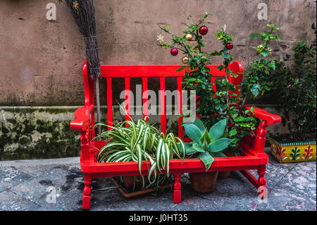 Banc rouge avec des pots de fleurs sur l'île d'Ortygie, partie historique de la ville de Syracuse, l'angle sud-est de l'île de la Sicile, Italie Banque D'Images