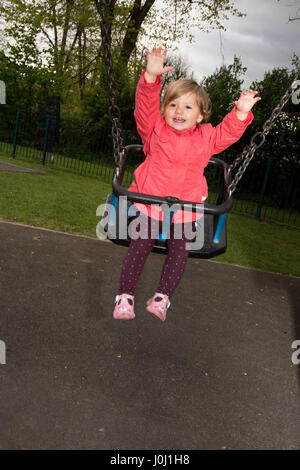 Tout-petit fille de 16 mois dans un parc public, aire de jeux Banque D'Images