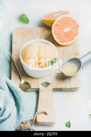 Sorbet pamplemousse rose avec des feuilles de menthe fraîche dans un bol Banque D'Images