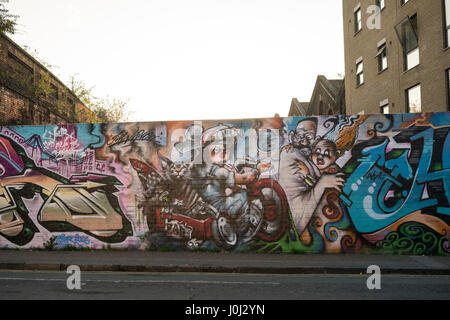 Un mur de brique jaune couvert de graffitis autour de la place et à venir des régions de Whitechapel, Bethnal Green et Shoreditch à l'Est de Londres Banque D'Images