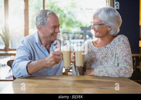 Senior couple toasting verres de café froid dans cafÃƒÂ© Banque D'Images
