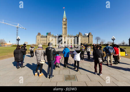 OTTAWA, CANADA - 15 Avril 2016 : les touristes prendre des photos devant le Parlement canadien à Ottawa. Banque D'Images