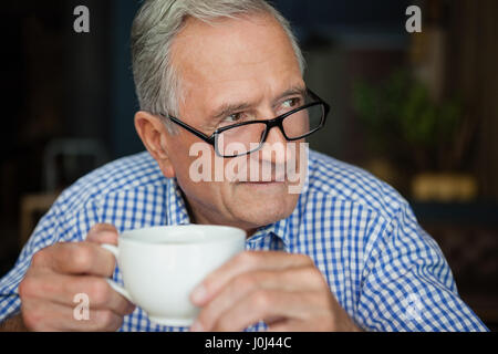 Happy man with coffee cup sitting at cafe Banque D'Images