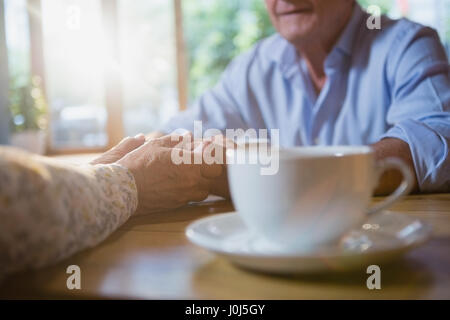 Senior couple holding hands while having coffee in cafÃƒÂ© Banque D'Images