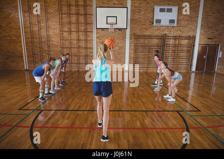 High school girl sur le point de prendre un tir de pénalité, tout en jouant au basket-ball dans la cour Banque D'Images