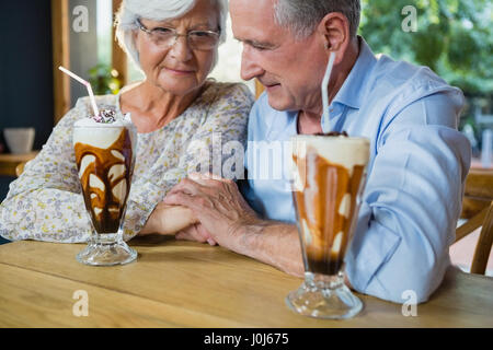 Senior couple holding hands while having coffee in cafÃƒÂ© Banque D'Images