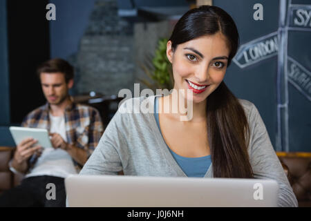 Portrait of young woman using laptop in cafÃƒÂ© Banque D'Images