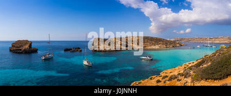 Comino, Malte - Vue Panoramique vue sur l'horizon de la célèbre et belle Blue Lagoon sur l'île de Comino avec voiliers, bateaux traditionnels Luzzu et tou Banque D'Images