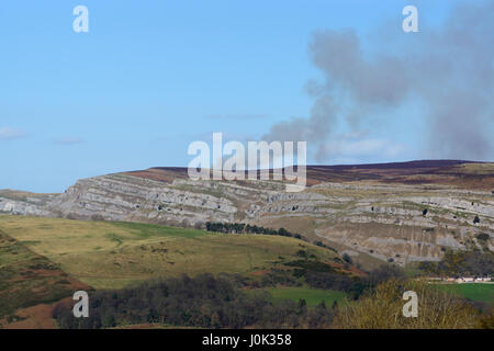 La fumée d'un feu lointain sur le Eglwyseg heath escarpement dans aux alentours de Worlds End beaute dans Llangollen Denbighshire Wales ci-dessus Banque D'Images