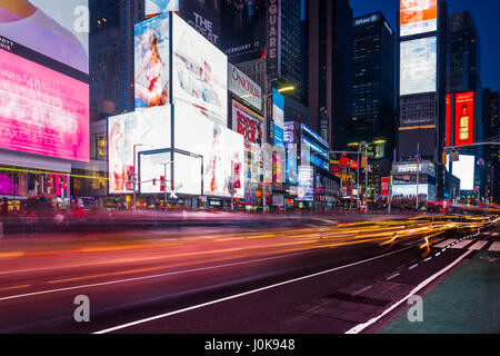 Times Square les bâtiments avec des lumières de voiture orange longue exposition en premier plan , New York Banque D'Images