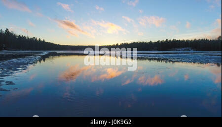 Coucher Soleil nuages mirroring sur lac gelé, dans siikajärvi Nuuksio national park, en Finlande Banque D'Images