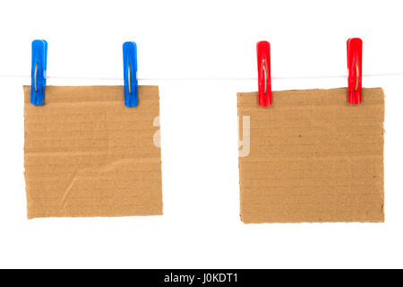 Carton vierge sur la corde est attachée à l'aide de rouge et bleu clothespin isolé sur fond blanc Banque D'Images