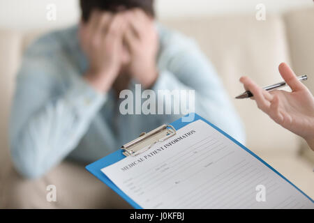 Femme médecin travaillant avec l'homme en colère, demande d'informations sur p Banque D'Images