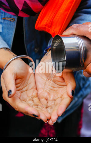 Femme qui a son laver les mains comme une importante partie de l'épuration ethnique Vaishakhi cérémonie, un festival religieux dans l'année religieuse sikh. Glasgow, Banque D'Images