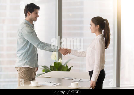 Accueil de jeunes hommes patron employée avec handshake à offi Banque D'Images