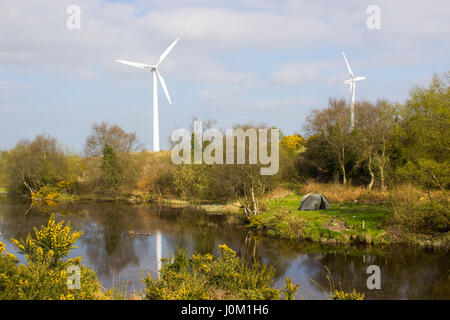 Une tente de deux hommes sur un bout de terre à côté du lac, dans l'ancien fonctionnement des mines de plomb à Conlig, avec une éolienne dans le contexte Banque D'Images