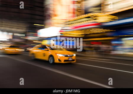 Yellow Taxi Cab Driving Through Times Square la nuit, New York, USA Banque D'Images