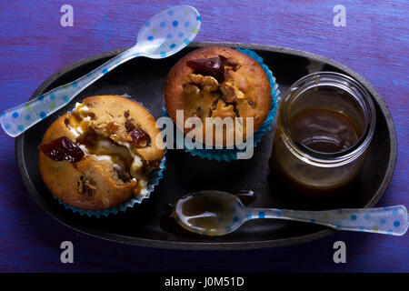 Muffins au caramel avec les dates, les noix et la sauce au caramel Banque D'Images