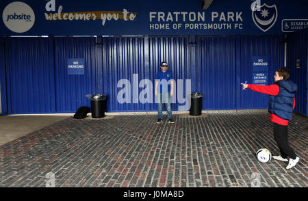 Vue générale d'enfants jouant au football à l'extérieur de la terre, devant le ciel parier League Deux match à Fratton Park, Portsmouth. Banque D'Images