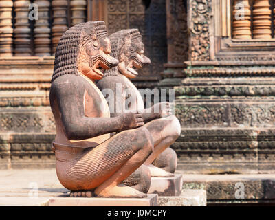 Lion et le singe, les gardians à Sculptures en grès rouge de Banteay Srei, temple Angkor Wat, au Cambodge Banque D'Images