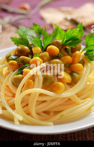 Spaghettis aux petits pois (conserve), le maïs et les feuilles de persil sur la plaque Banque D'Images